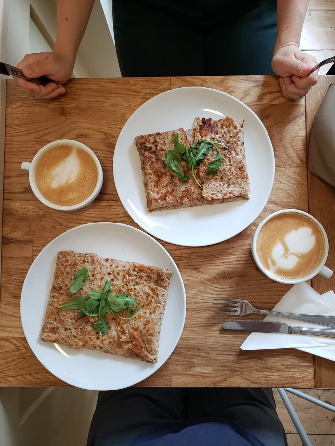 Deux galettes de sarrasin garnies, pliées en carré et servies sur assiette