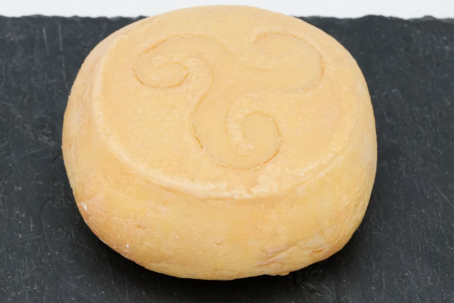 Curé nantais entier à croûte lavée orangée, posé sur une ardoise