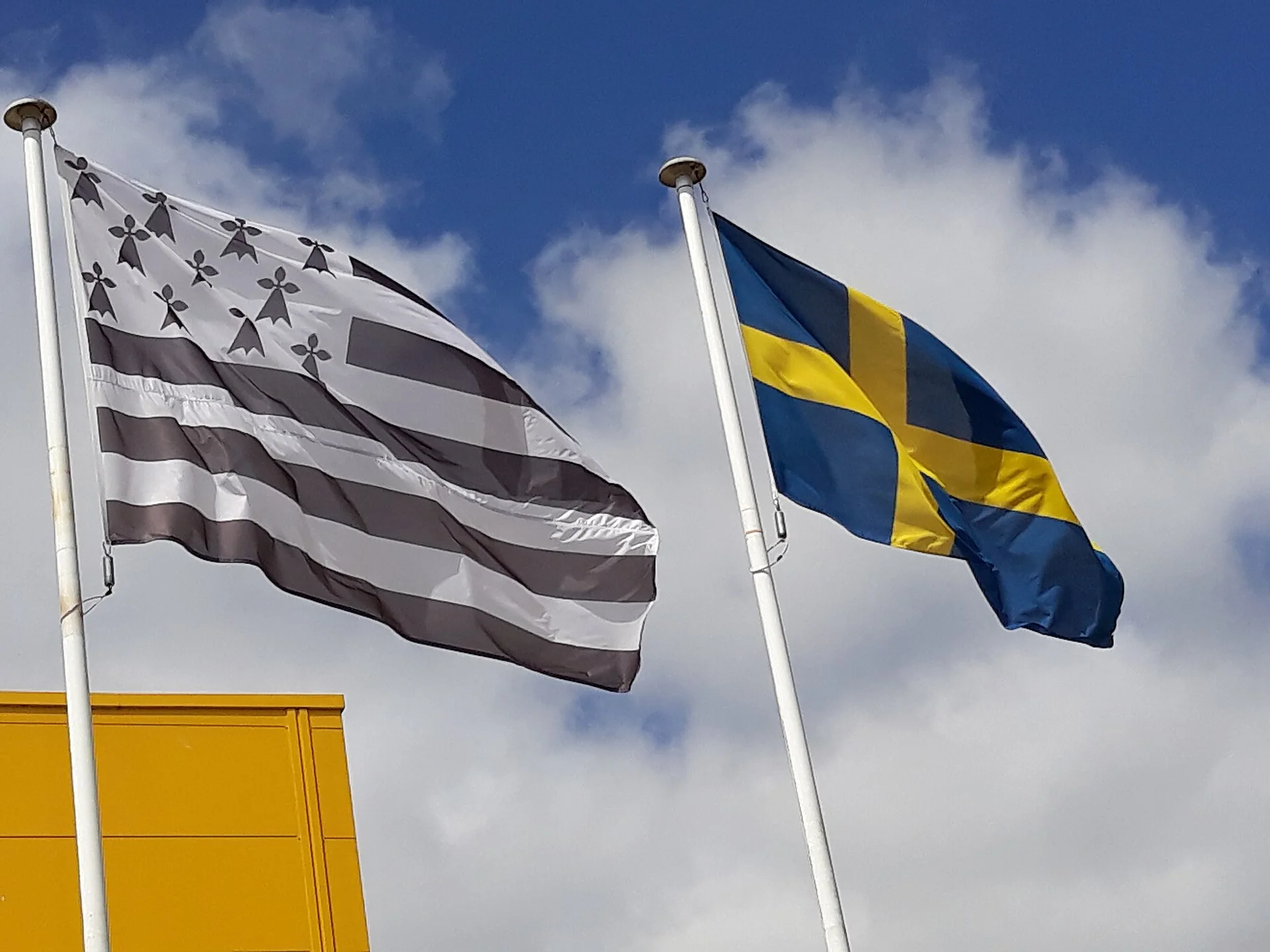 Drapeau breton et drapeau suédois de même taille sur deux mâts voisins